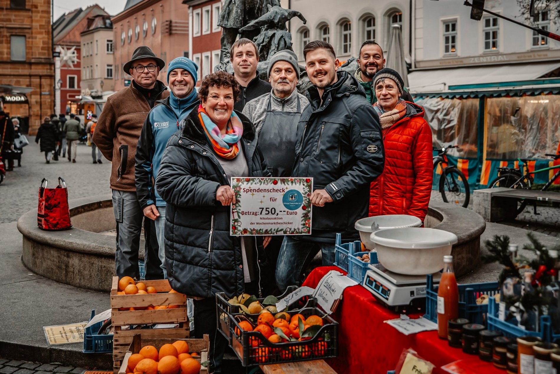 Das Foto zeigt die Marktbeschicker bei der Übergabe einer Spende in Höhe von 750 Euro an Kerstin Borchert vom Verein Nino’s Freunde.
