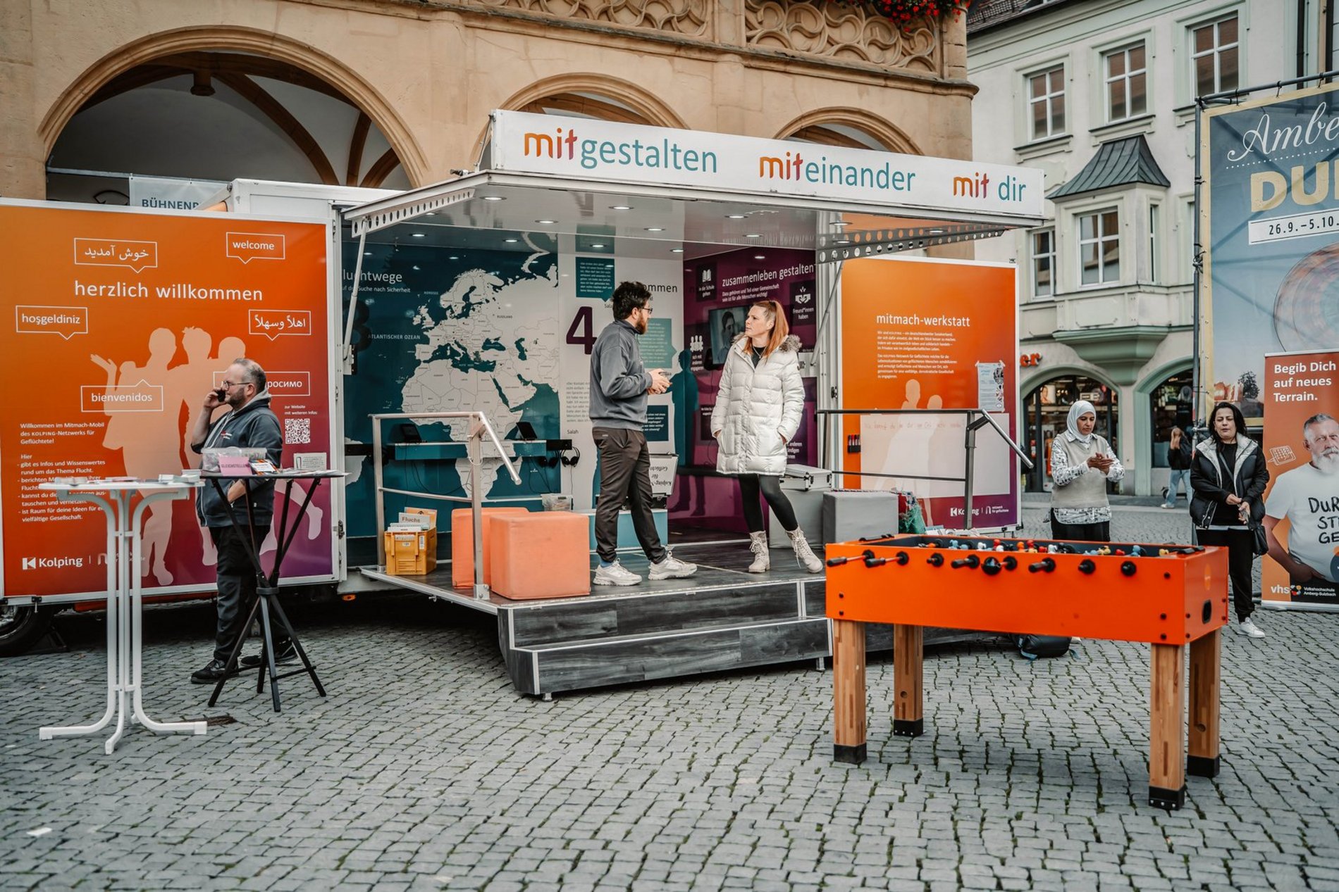 Das Foto zeigt das Mitmach-Mobil des KOLPING-Netzwerks für Geflüchtete auf dem Amberger Marktplatz.