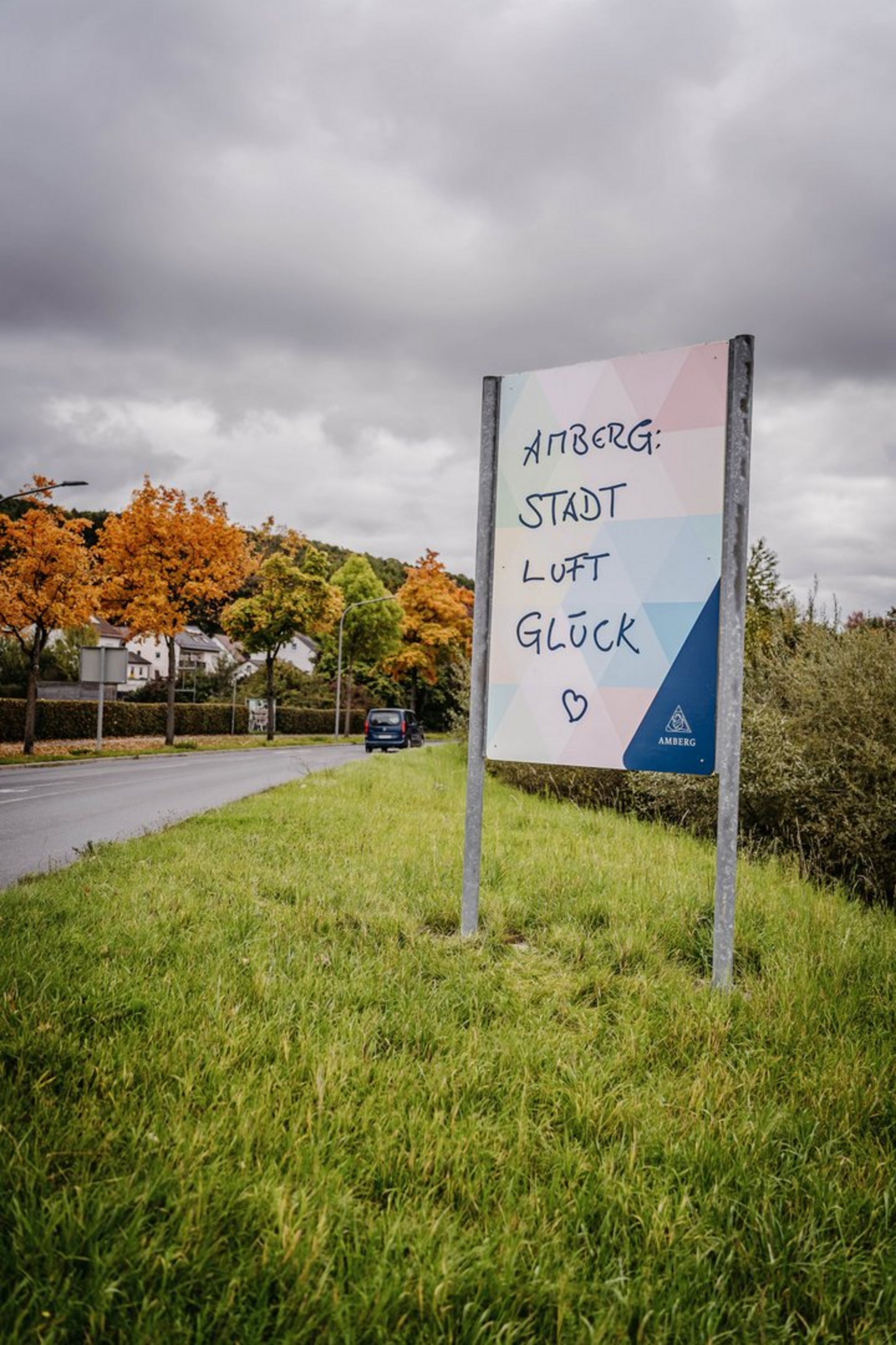 Das Foto zeigt die neue Stadteingangstafel in Raigering mit dem Spruch „Amberg: Stadt, Luft, Glück“.