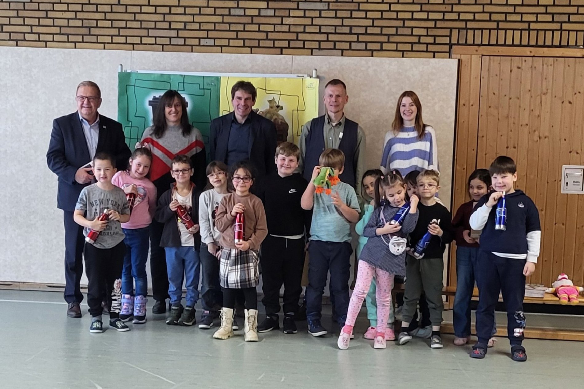 Zweiter Bürgermeister Martin J. Preuß (links), Sonderschulrektor Ralph Schmitt (Mitte) sowie Lehrkräfte und Mitarbeiter der städtischen Abfallberatung freuten sich mit den Erstklässlern über ihre neuen personalisierten Trinkflaschen. Foto/Copyright: Elena Berschneider, Stadt Amberg