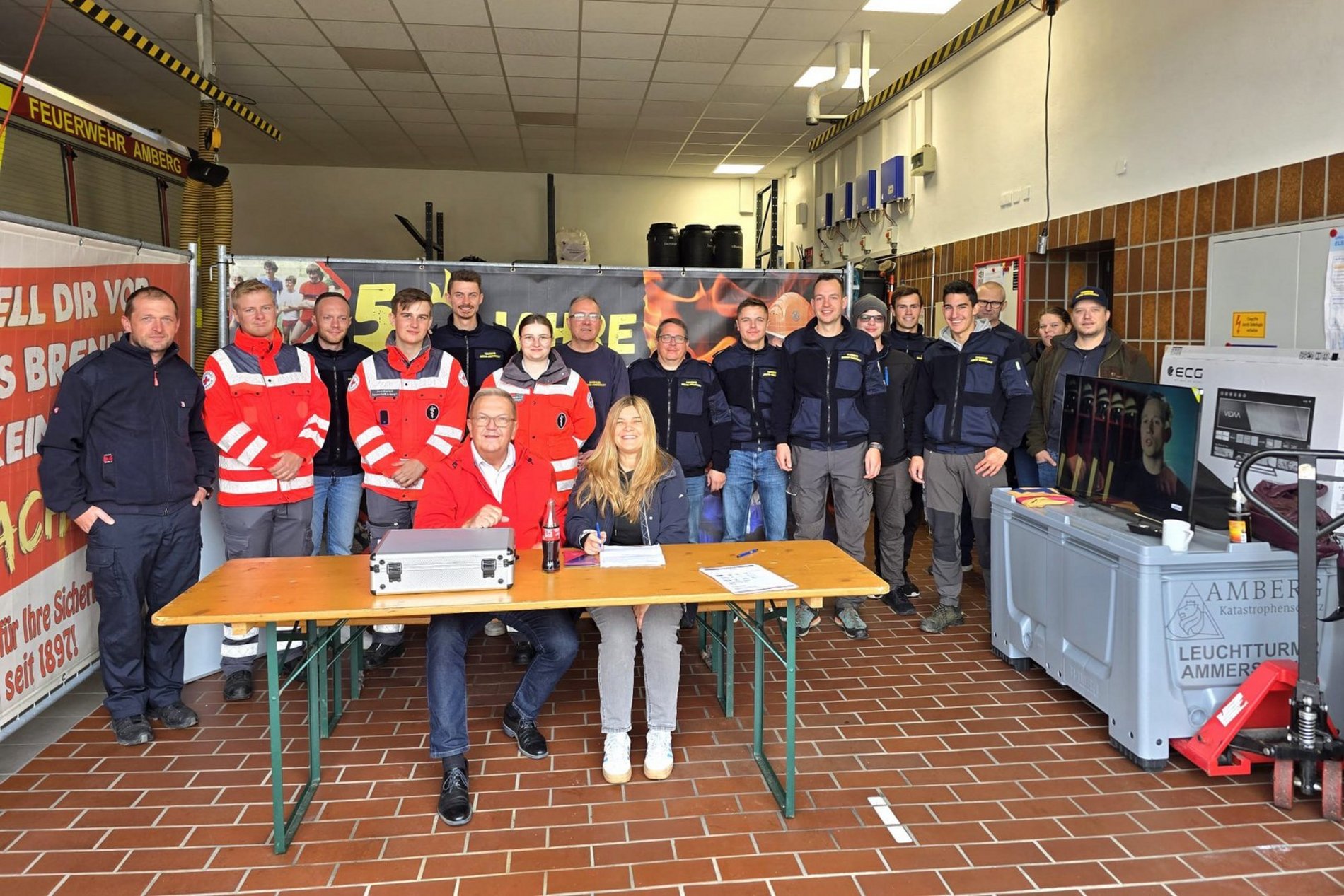 Blick in einen der rasch eingerichteten Leuchttürme in Ammersricht mit Bürgermeister Martin J. Preuß (1. Reihe/sitzend) und beteiligten Einsatzkräften. Foto/Copyright: Simon Hauck, Stadt Amberg